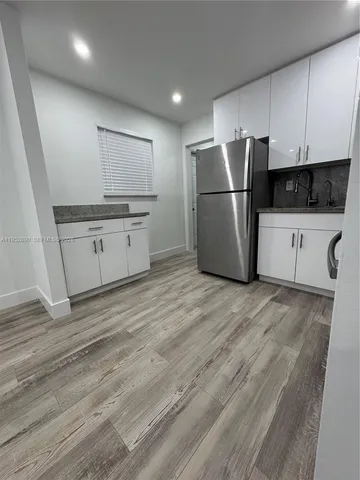 a kitchen with stainless steel appliances a refrigerator sink and white cabinets