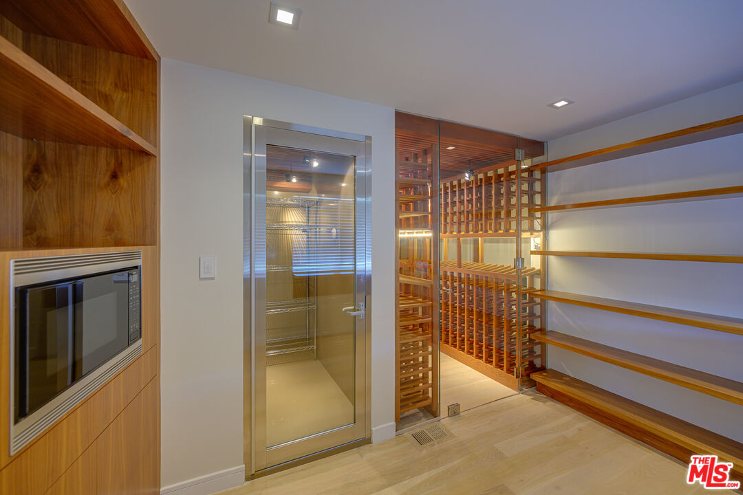 1235 Tower Road Beverly Hills, CA 90210 - Photo 17 of 31 a room with walk in closet and wooden floor