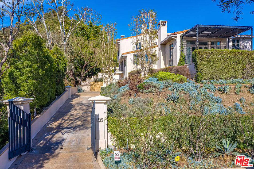 1235 Tower Road Beverly Hills, CA 90210 - Photo 2 of 31 a front view of a house with a yard