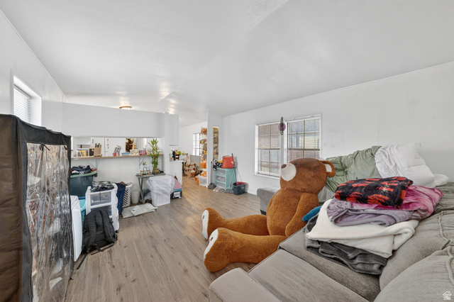 262 Hidden View Drive, Unit 94 Sandy, UT 84070 - Photo 4 of 18 Living area with light wood-type flooring and vaulted ceiling