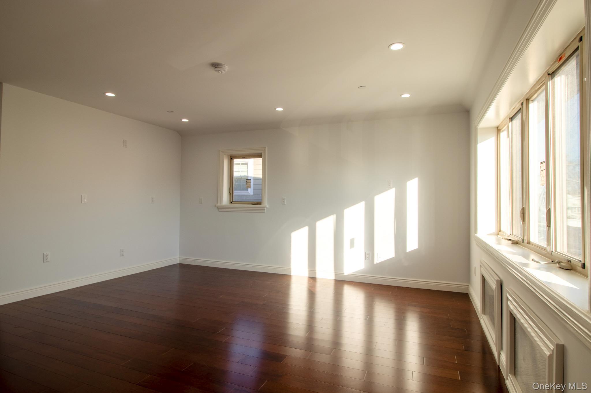 924 129th Street Queens, NY 11356 - Photo 12 of 23 Unfurnished room with dark wood-type flooring and recessed lighting