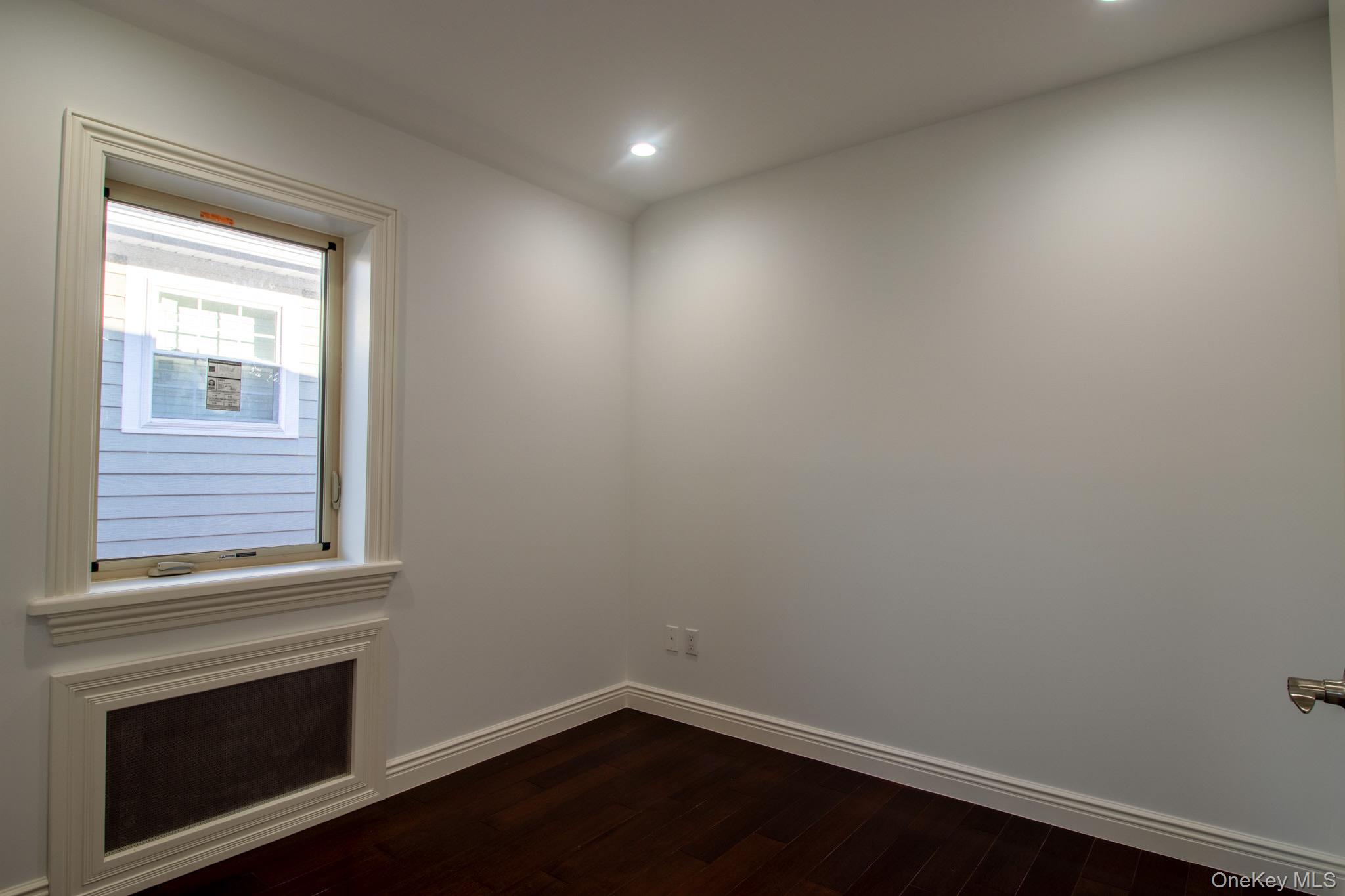 924 129th Street Queens, NY 11356 - Photo 15 of 23 Unfurnished room featuring dark wood-type flooring and recessed lighting
