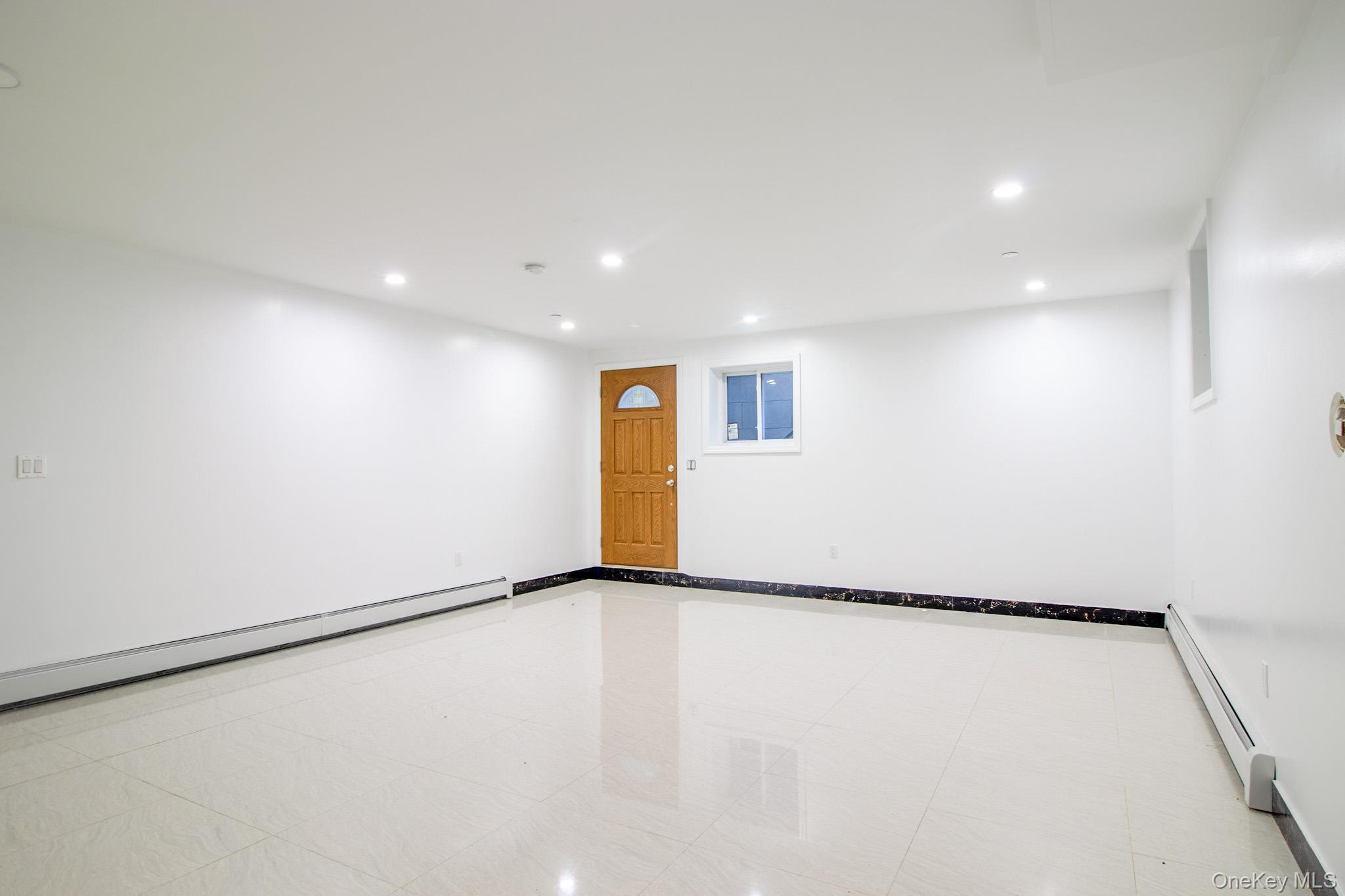 924 129th Street Queens, NY 11356 - Photo 17 of 23 Spare room with recessed lighting, a baseboard radiator, and light tile patterned floors