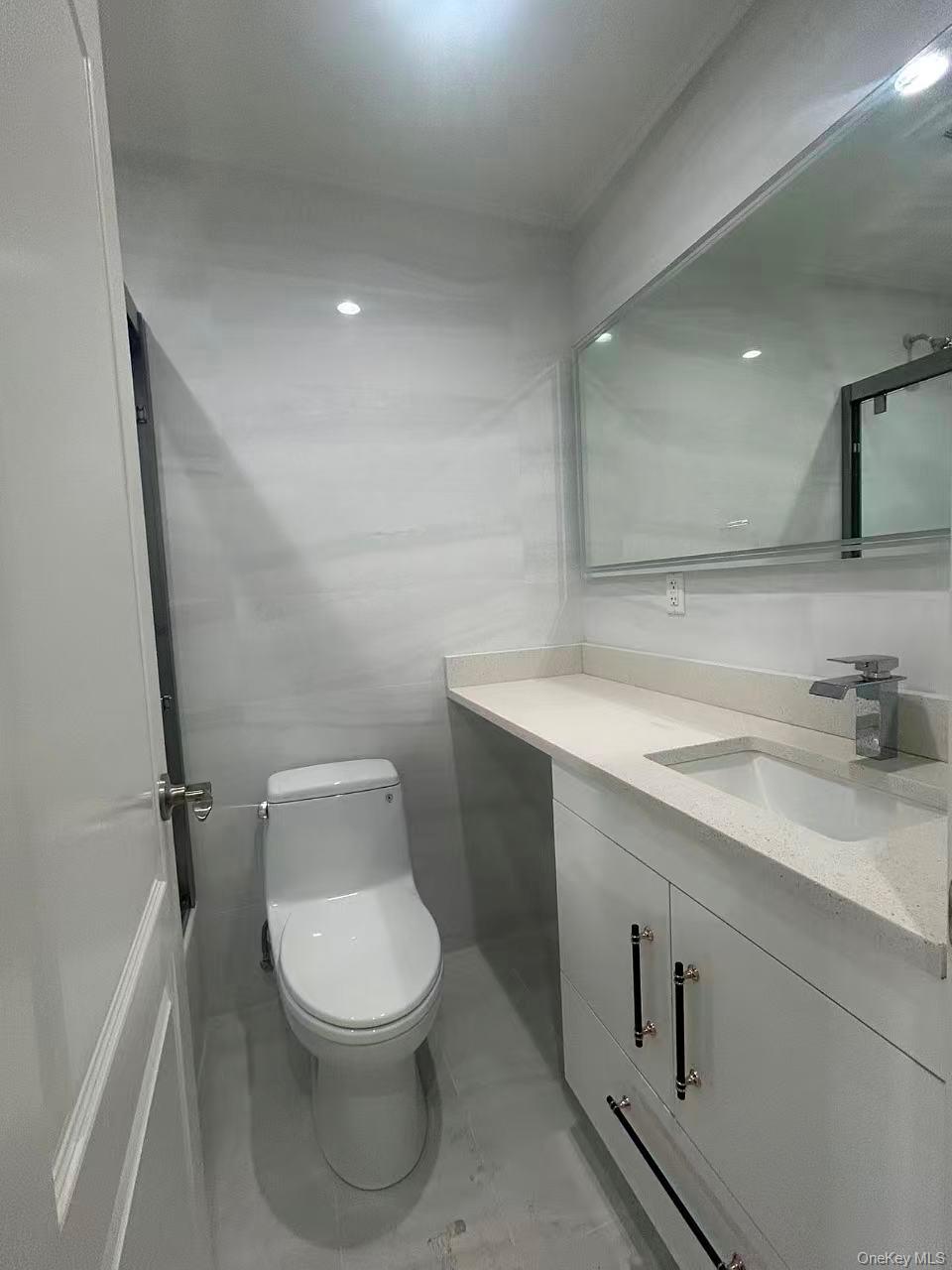 924 129th Street Queens, NY 11356 - Photo 20 of 23 Bathroom featuring vanity and tile walls