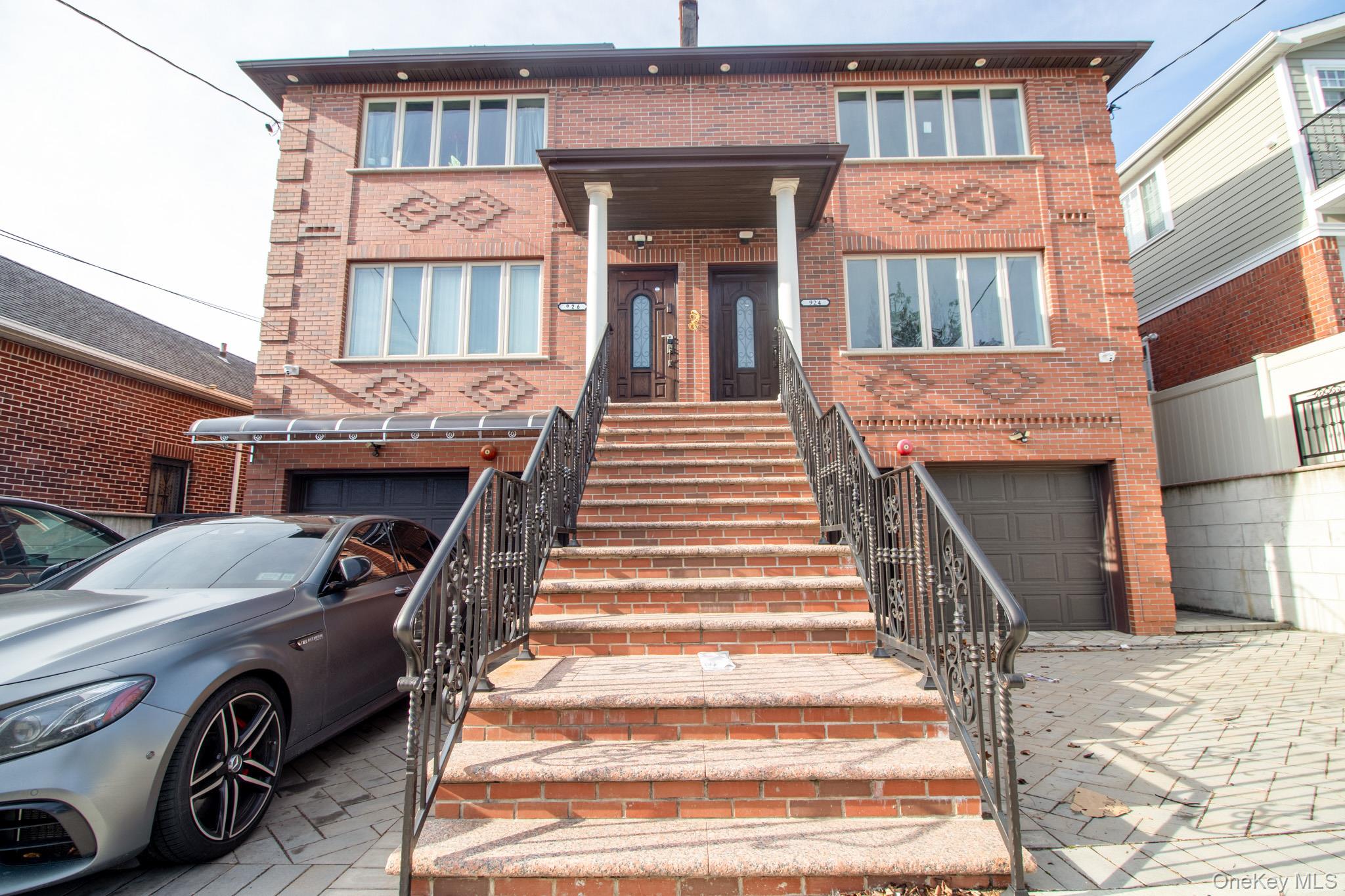924 129th Street Queens, NY 11356 - Photo 2 of 23 View of front facade with stairs, brick siding, and an attached garage