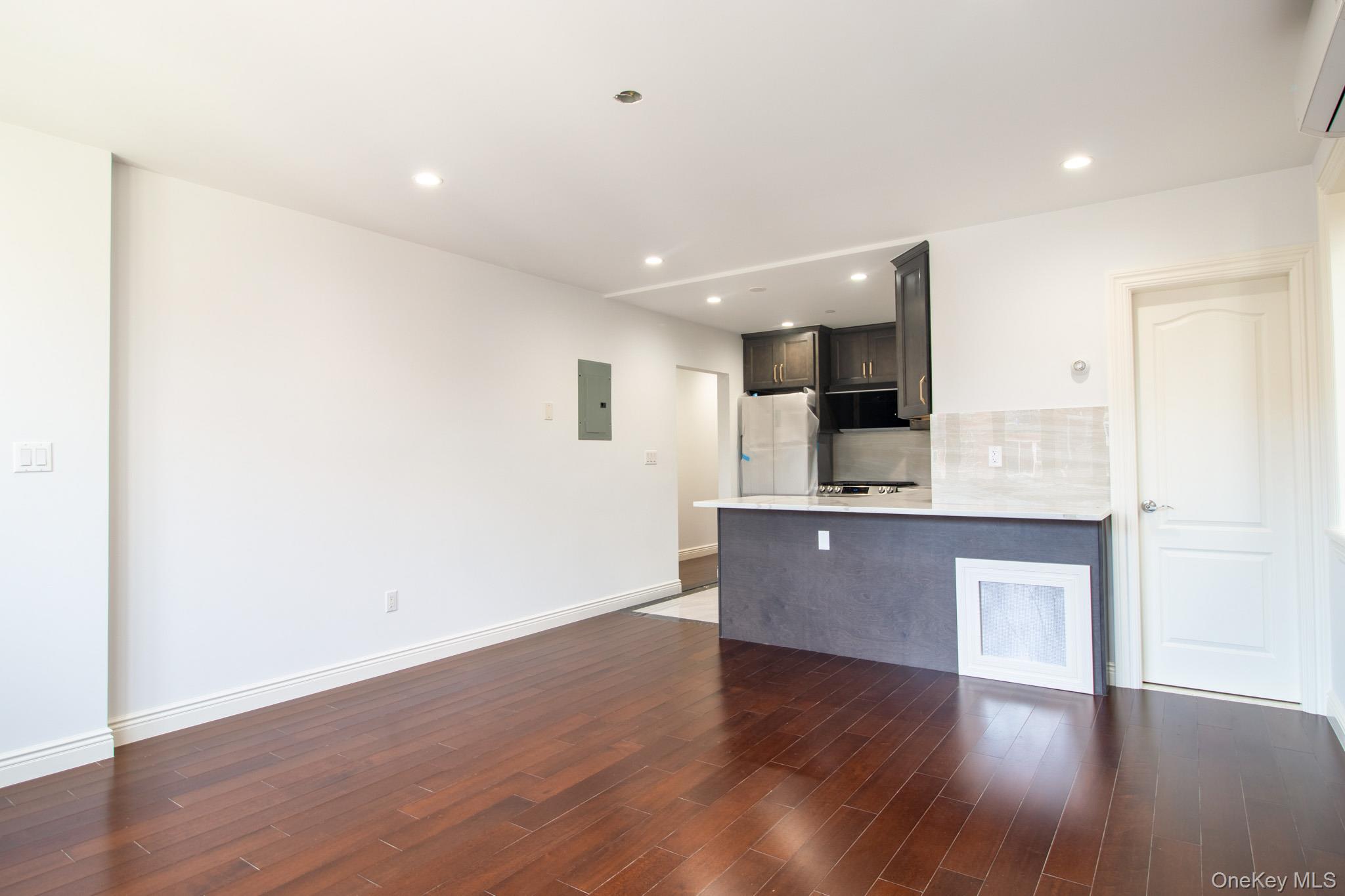 924 129th Street Queens, NY 11356 - Photo 7 of 23 Kitchen with decorative backsplash, recessed lighting, dark wood-type flooring, a peninsula, and white fridge