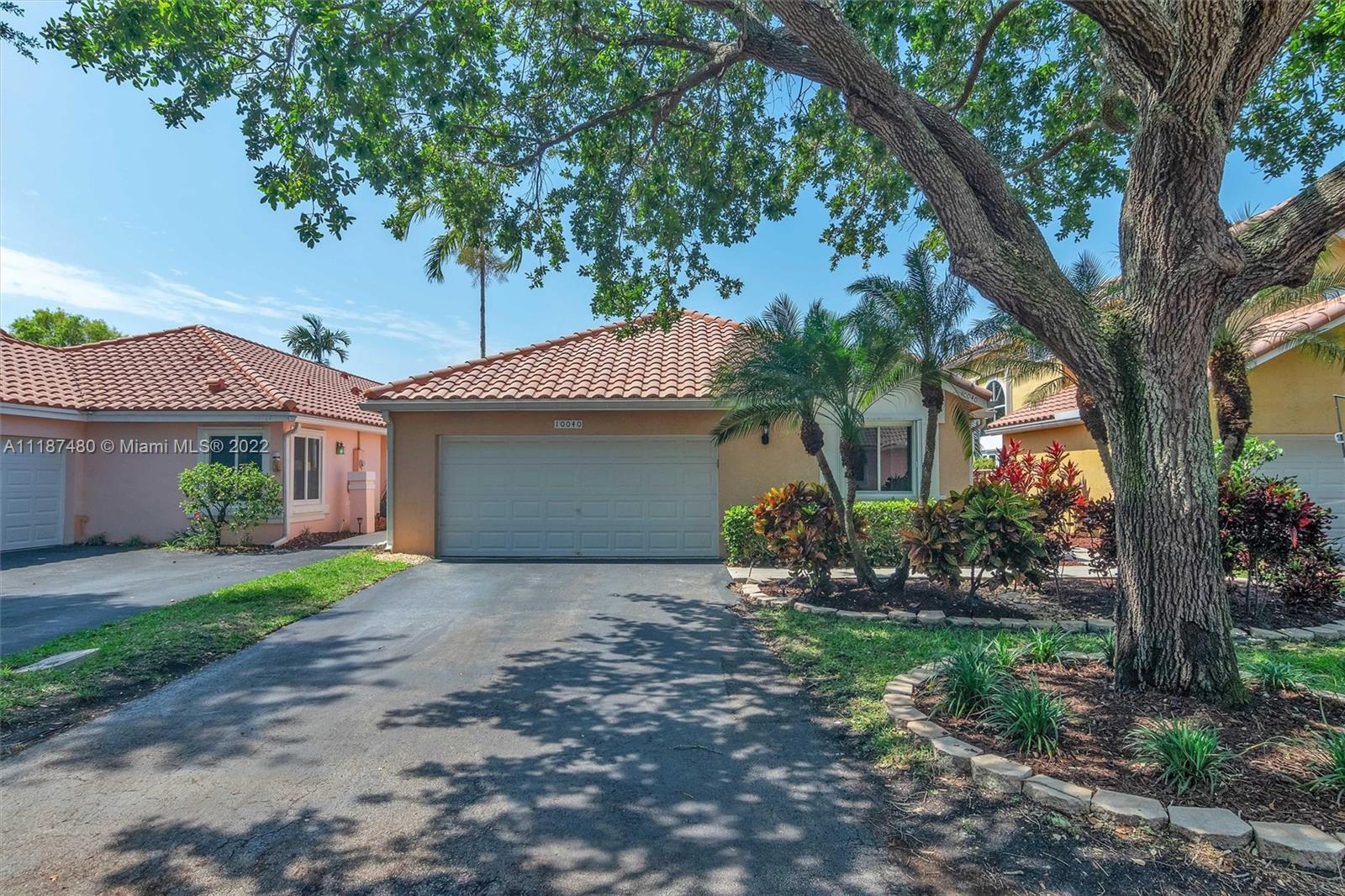 a front view of a house with a garden and yard