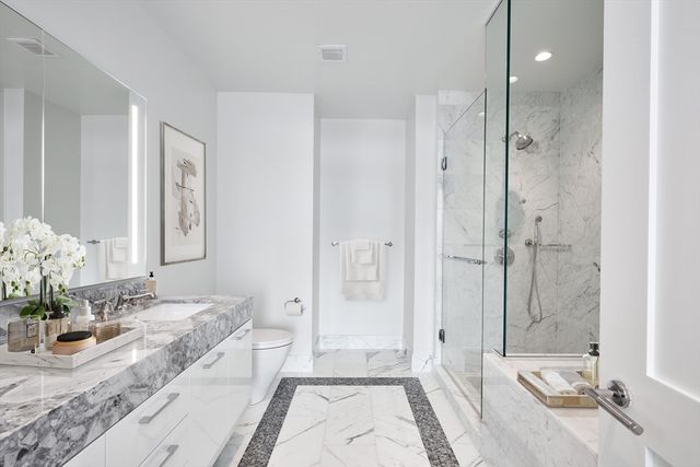 a bathroom with a granite countertop sink a mirror and a shower