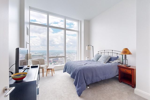 a bedroom with a bed and large windows