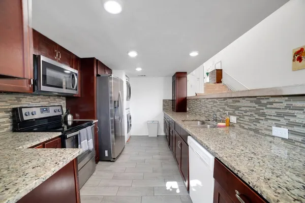 a kitchen with stainless steel appliances granite countertop a sink stove and refrigerator