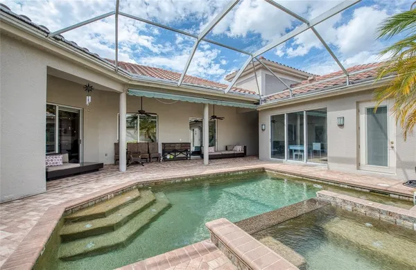 a view of a house with pool and sitting area