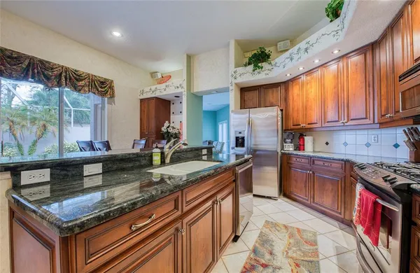 a kitchen with stainless steel appliances granite countertop a stove a sink and a refrigerator