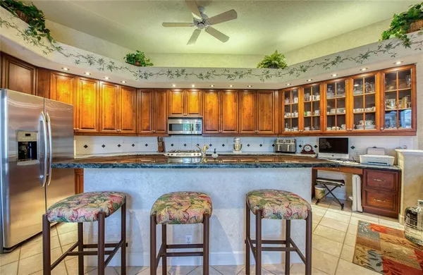 a kitchen with stainless steel appliances a dining table chairs sink and cabinets