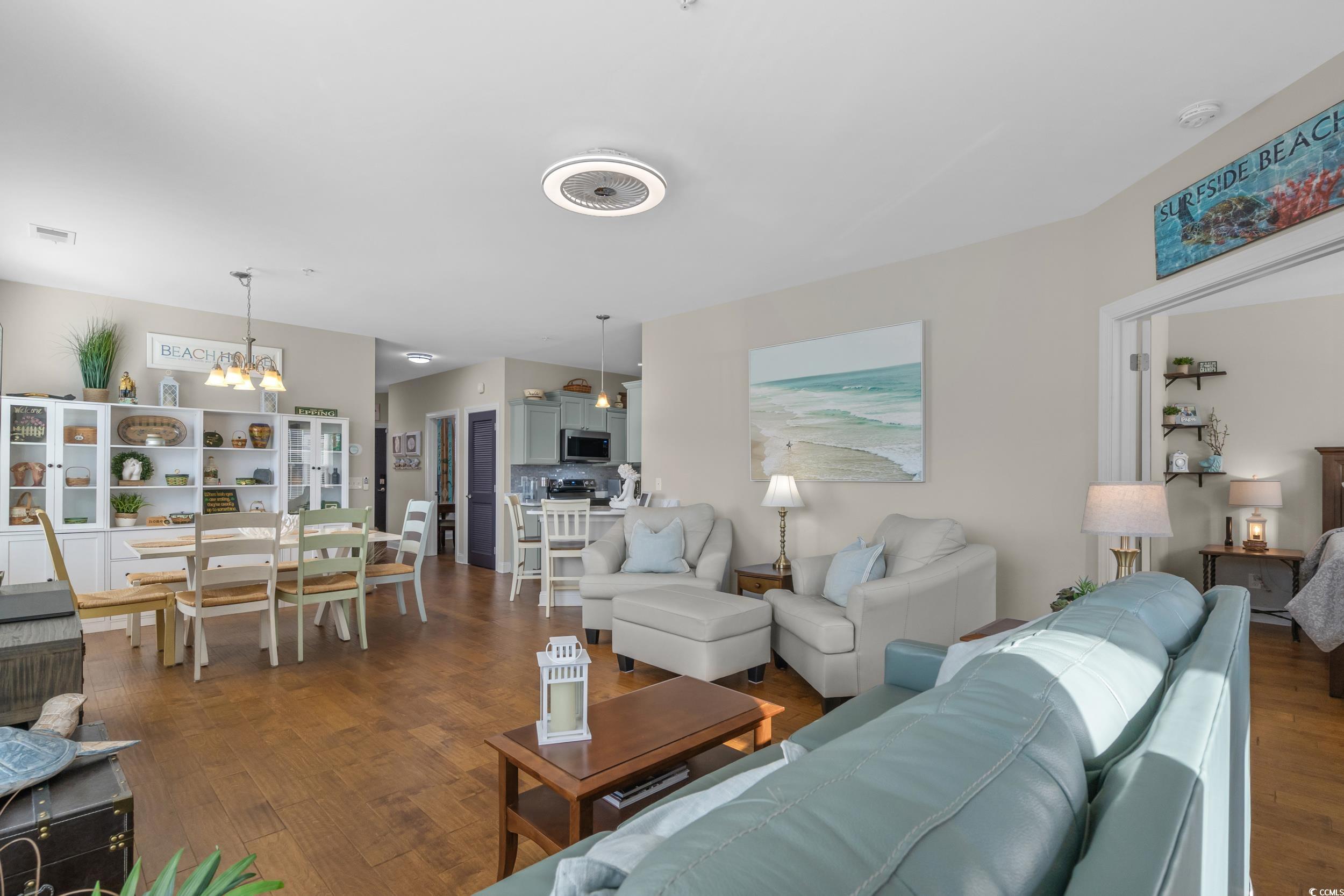 142 Ella Kinley Circle, Unit 304 Myrtle Beach, SC 29588 - Photo 11 of 38 Living area featuring dark wood-type flooring and a chandelier