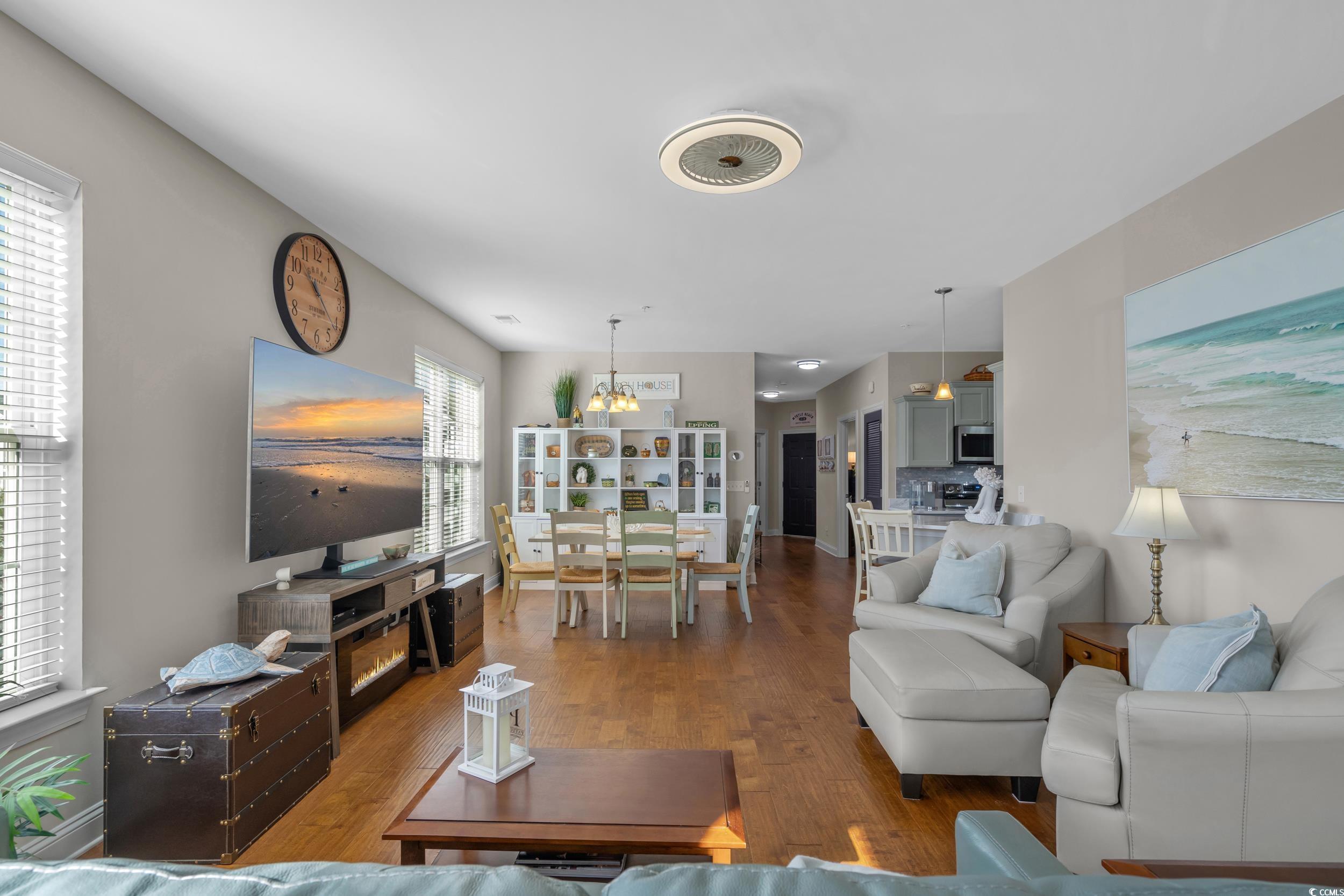 142 Ella Kinley Circle, Unit 304 Myrtle Beach, SC 29588 - Photo 12 of 38 Living area featuring wood finished floors and a chandelier
