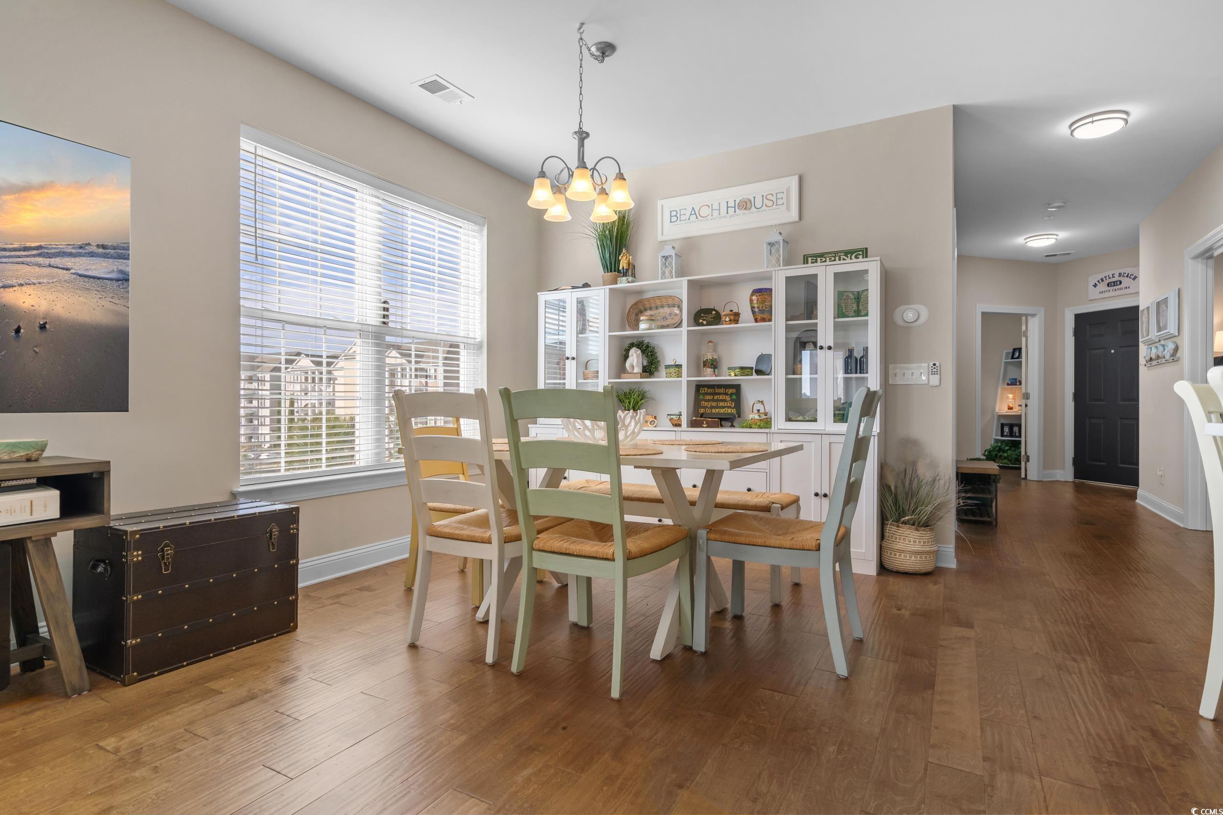 142 Ella Kinley Circle, Unit 304 Myrtle Beach, SC 29588 - Photo 13 of 38 Dining area featuring hardwood / wood-style flooring and a chandelier
