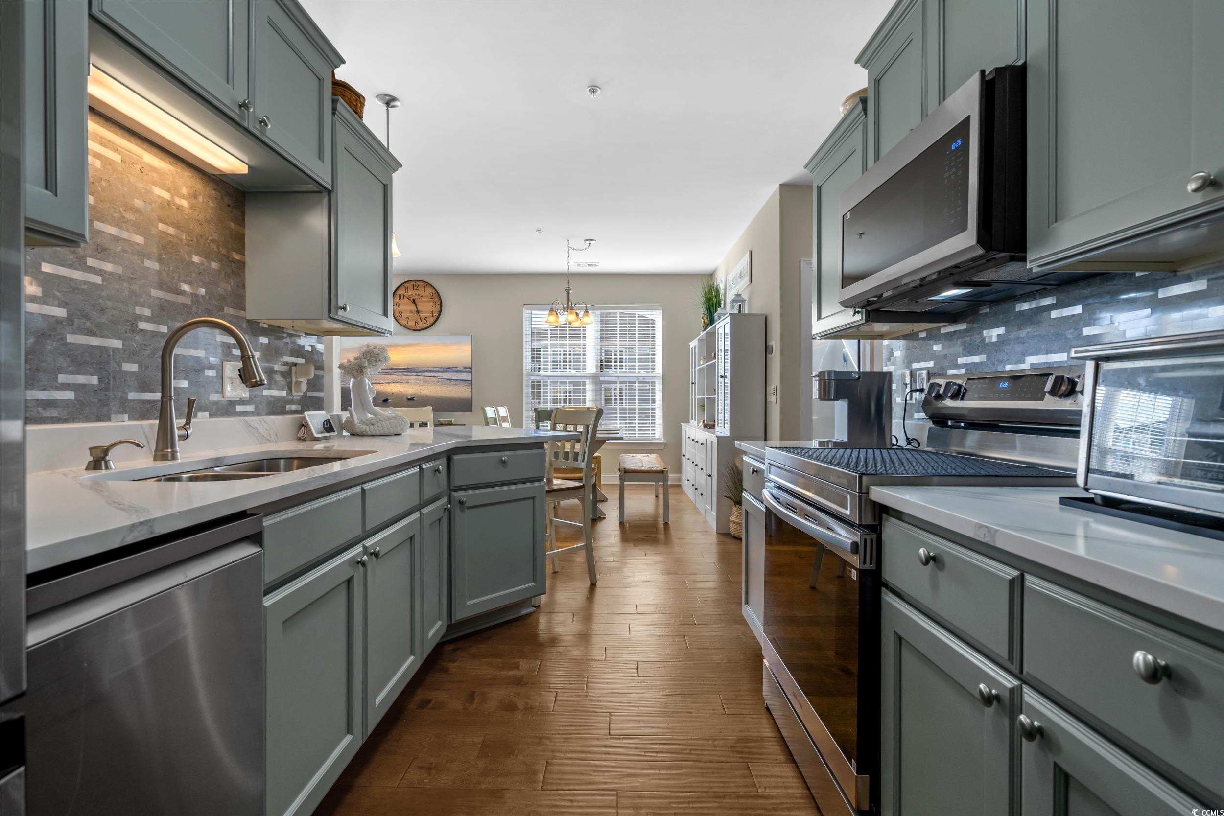 142 Ella Kinley Circle, Unit 304 Myrtle Beach, SC 29588 - Photo 21 of 38 Kitchen featuring gray cabinets, stainless steel appliances, tasteful backsplash, and pendant lighting