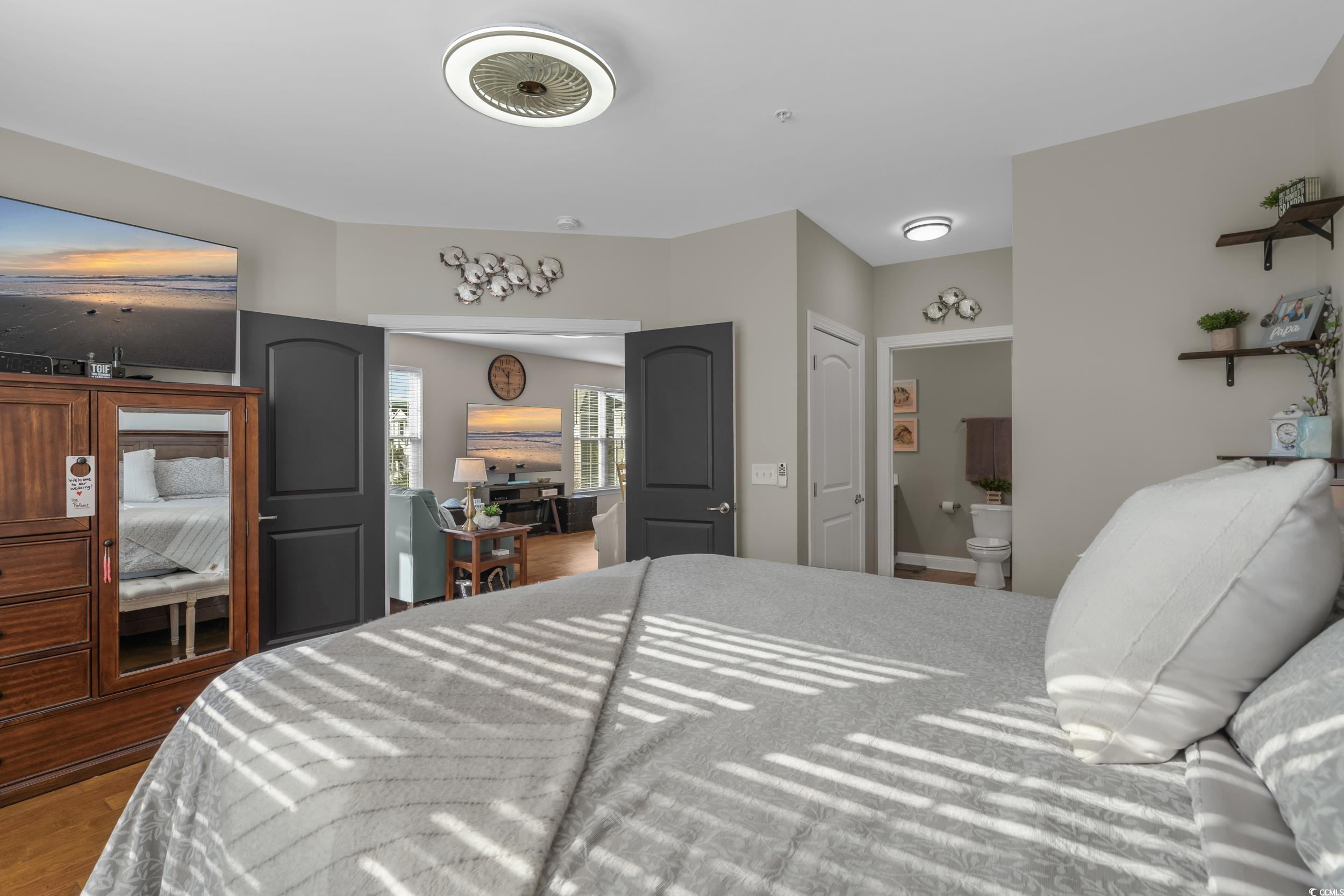 142 Ella Kinley Circle, Unit 304 Myrtle Beach, SC 29588 - Photo 24 of 38 Bedroom with ensuite bathroom and wood finished floors