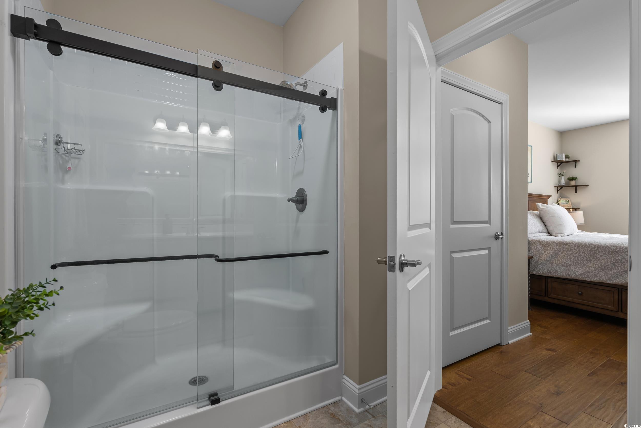 142 Ella Kinley Circle, Unit 304 Myrtle Beach, SC 29588 - Photo 26 of 38 Ensuite bathroom with a shower stall and wood finished floors