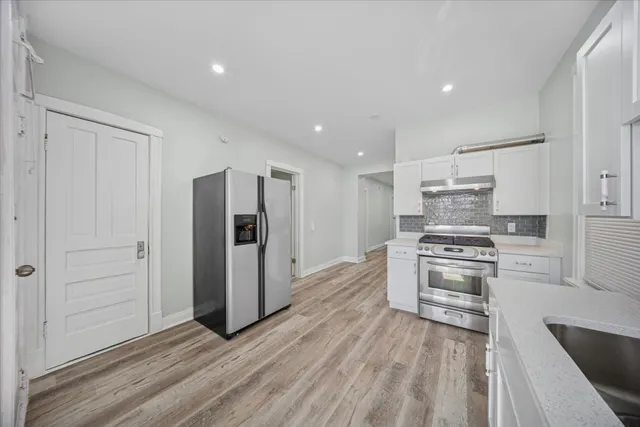 a kitchen with stainless steel appliances a refrigerator and a stove top oven