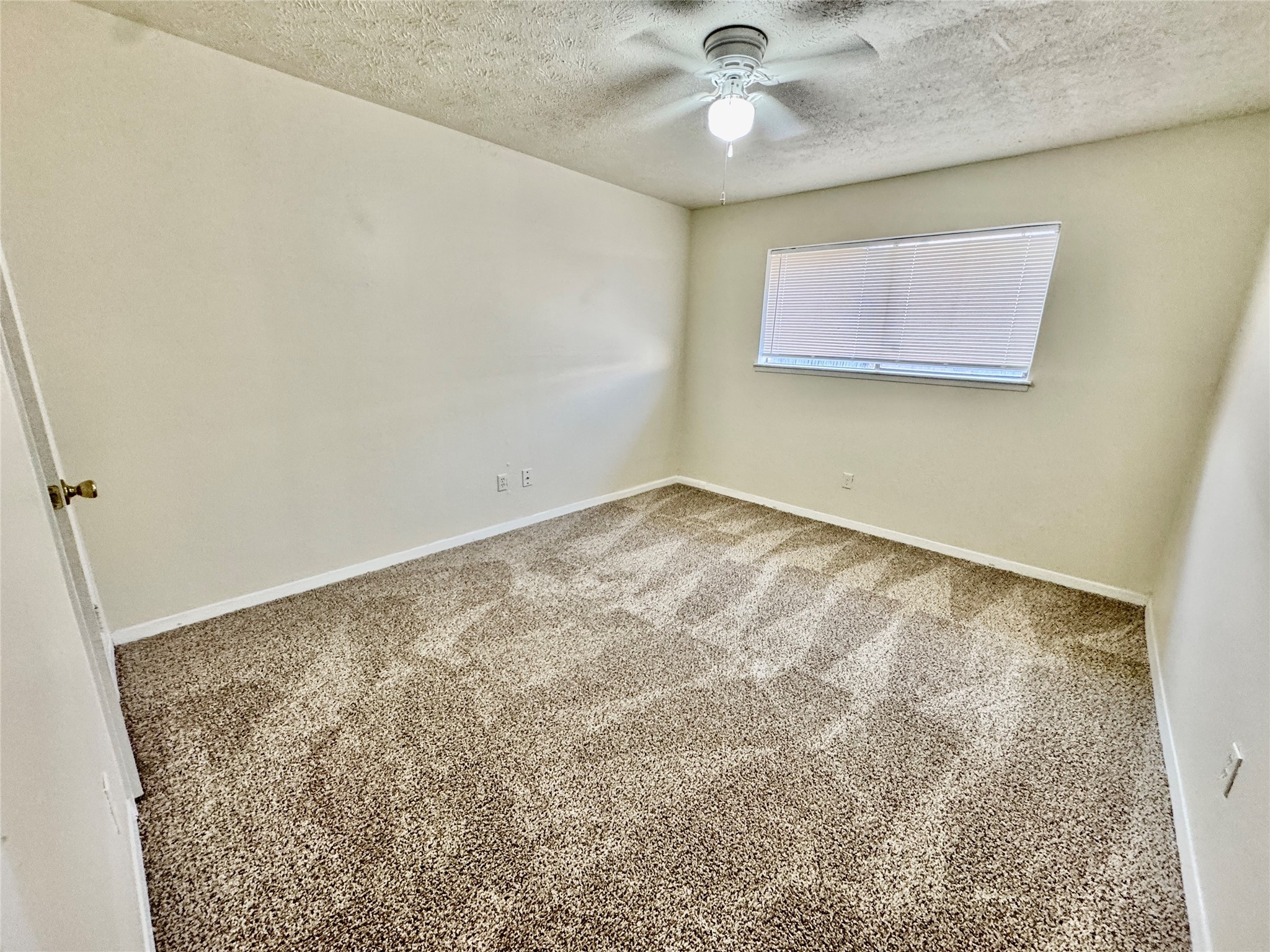 10131 Sagedale Drive Houston, TX 77089 - Photo 17 of 21 an empty room with a ceiling fan and carpet