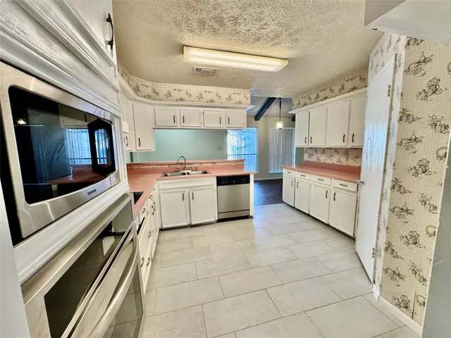 a kitchen with stainless steel appliances a stove sink and cabinets
