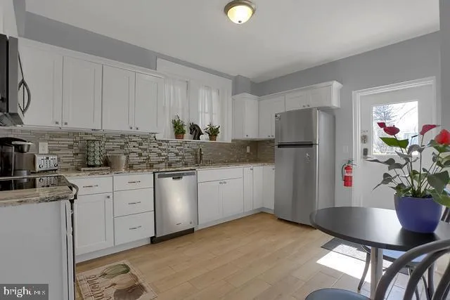 a kitchen with stainless steel appliances granite countertop a refrigerator sink and cabinets