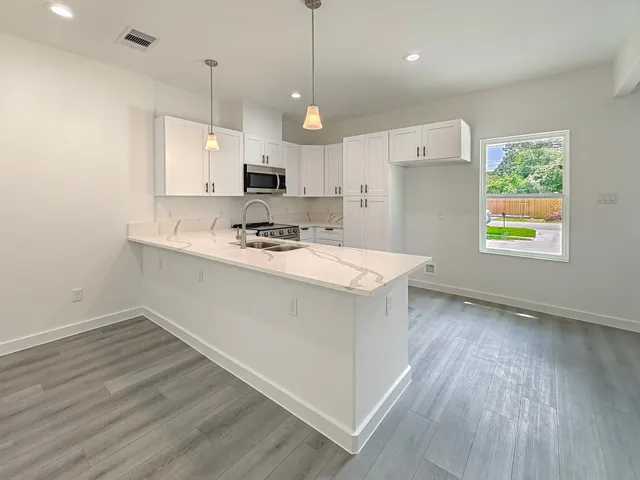 a kitchen with a sink a stove a refrigerator and a window