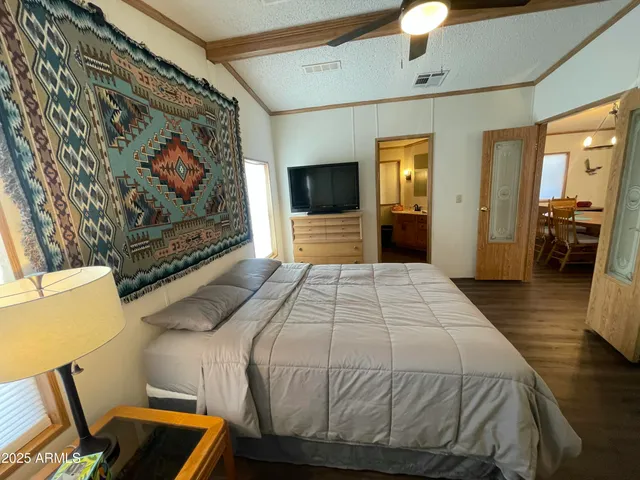 a bedroom with a bed and wooden floor