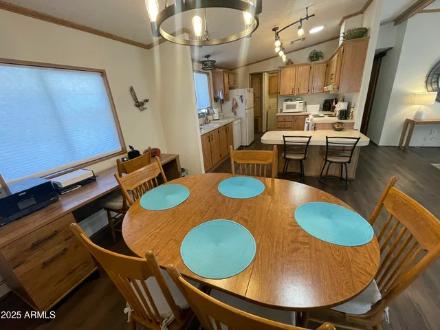 a kitchen with stainless steel appliances granite countertop a table chairs stove and a microwave