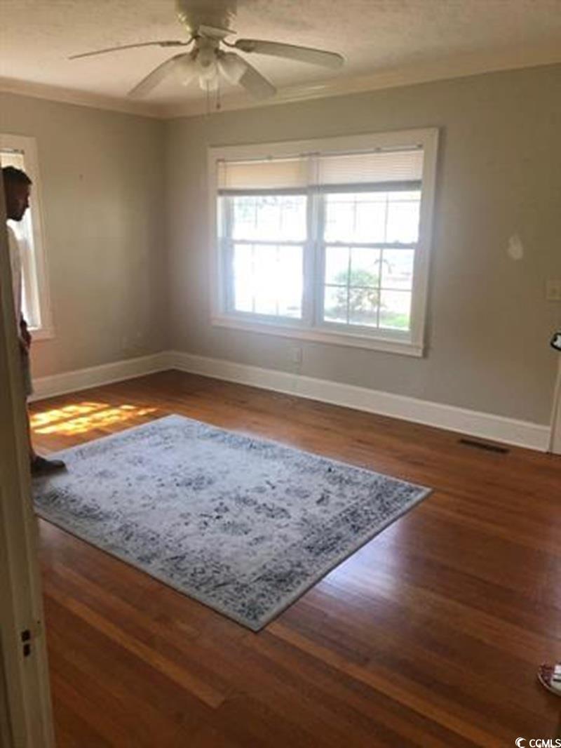 414 36th Avenue North Myrtle Beach, SC 29577 - Photo 13 of 22 Spare room with ceiling fan, dark wood-type flooring, and ornamental molding