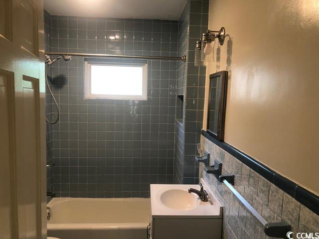 414 36th Avenue North Myrtle Beach, SC 29577 - Photo 15 of 22 Bathroom with vanity, tub / shower combination, and tile walls