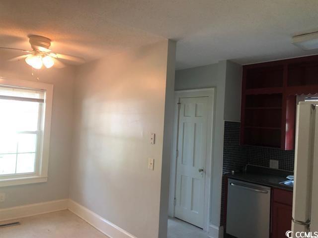 414 36th Avenue North Myrtle Beach, SC 29577 - Photo 17 of 22 Kitchen with dark countertops, stainless steel dishwasher, white fridge, ceiling fan, and open shelves