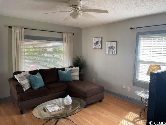 414 36th Avenue North Myrtle Beach, SC 29577 - Photo 6 of 22 Living room featuring wood finished floors, a textured ceiling, plenty of natural light, and a ceiling fan