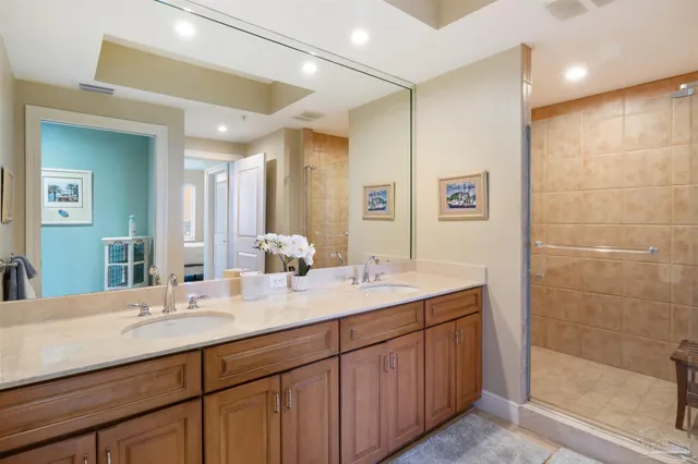 a bathroom with a double vanity sink mirror and shower