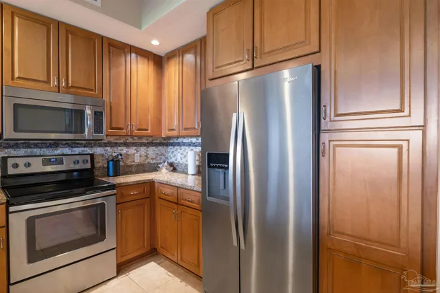 a kitchen with stainless steel appliances granite countertop a refrigerator stove and microwave