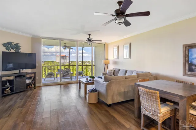 a living room with furniture flat screen tv and a large window