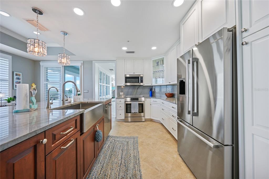 2590 North Beach Road, Unit 5 Englewood, FL 34223 - Photo 6 of 45 a kitchen with stainless steel appliances a refrigerator sink and microwave