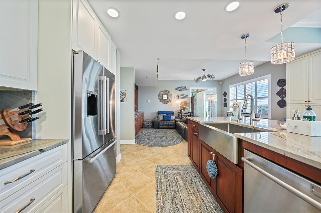 2590 North Beach Road, Unit 5 Englewood, FL 34223 - Photo 7 of 45 a large kitchen with stainless steel appliances kitchen island granite countertop a refrigerator and a sink