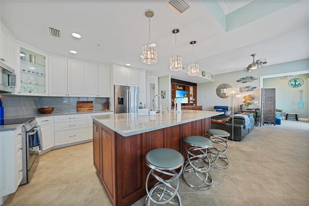 2590 North Beach Road, Unit 5 Englewood, FL 34223 - Photo 8 of 45 a kitchen with stainless steel appliances granite countertop a sink and a refrigerator