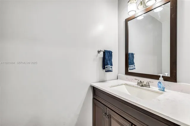 a bathroom with a granite countertop sink and a mirror