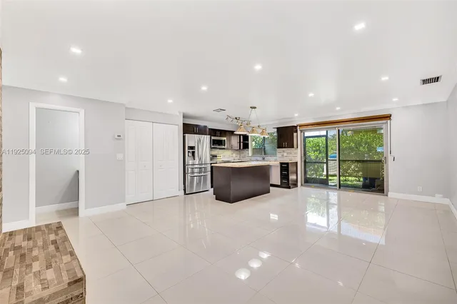 a open kitchen with stainless steel appliances a refrigerator and a sink