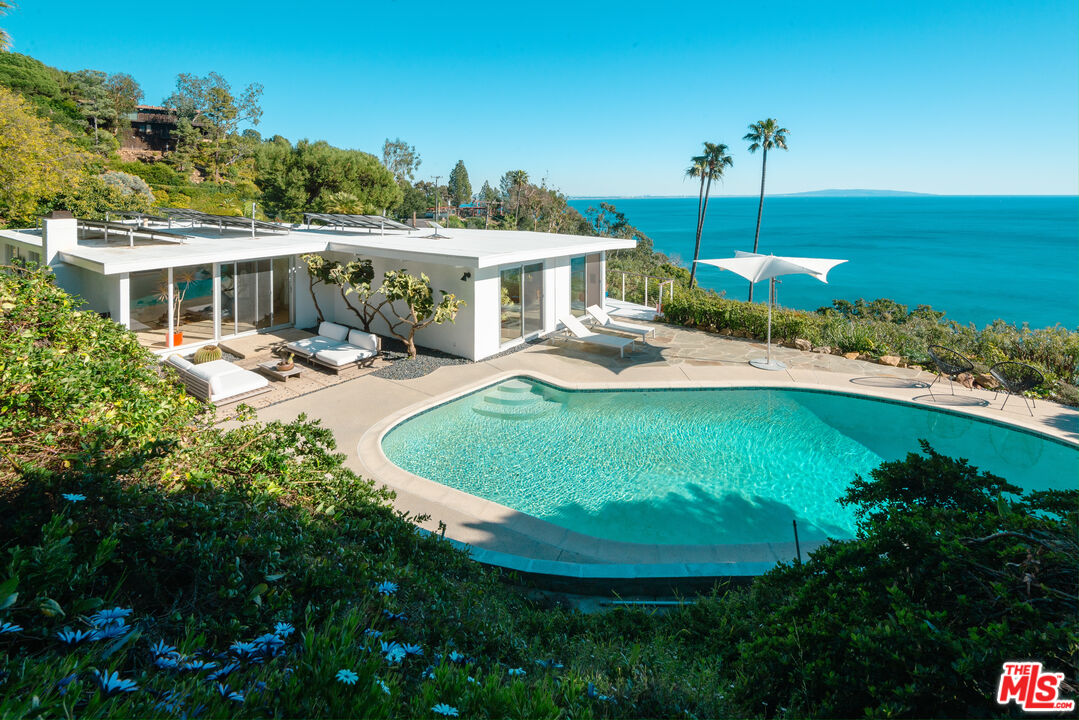 a view of a house with pool and chairs