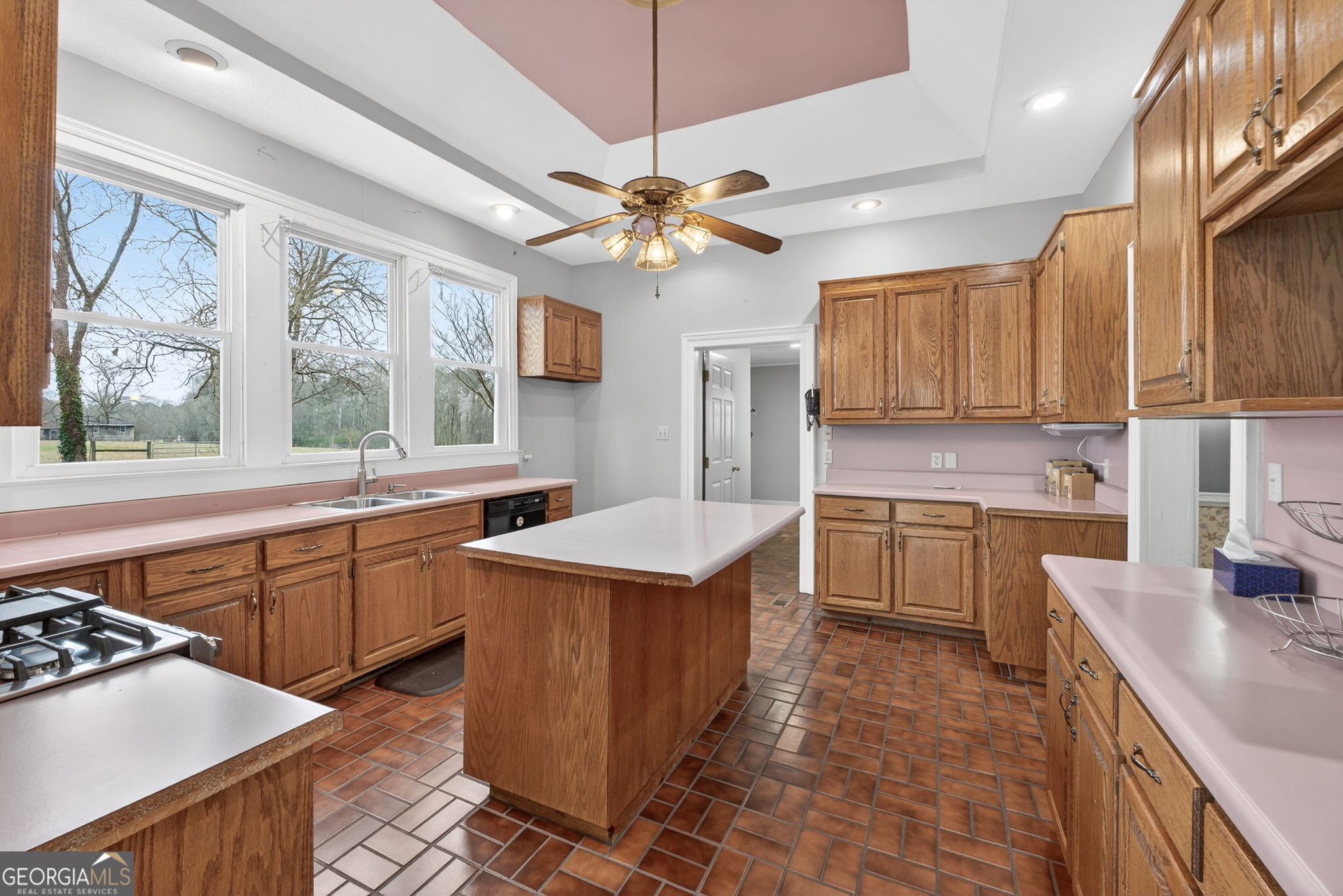 402 Tom Bell Road Milner, GA 30257 - Photo 22 of 75 a kitchen with a stove a sink a window and cabinetry