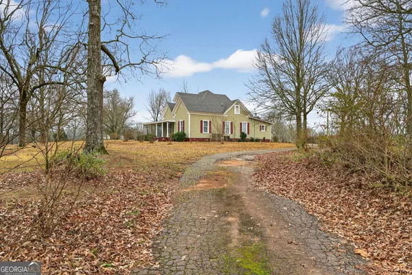 a view of a house with backyard and tree