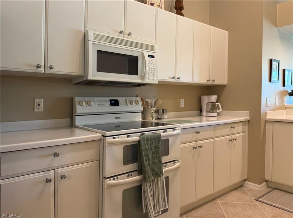 8165 Celeste Drive, Unit 2228 Naples, FL 34113 - Photo 13 of 30 a kitchen with stainless steel appliances granite countertop a sink and a microwave