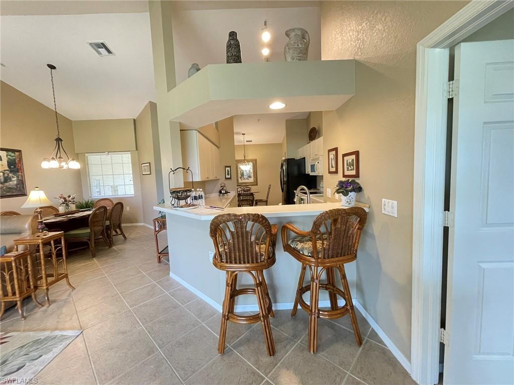 8165 Celeste Drive, Unit 2228 Naples, FL 34113 - Photo 14 of 30 a room with stainless steel appliances kitchen island granite countertop furniture and a view of living room