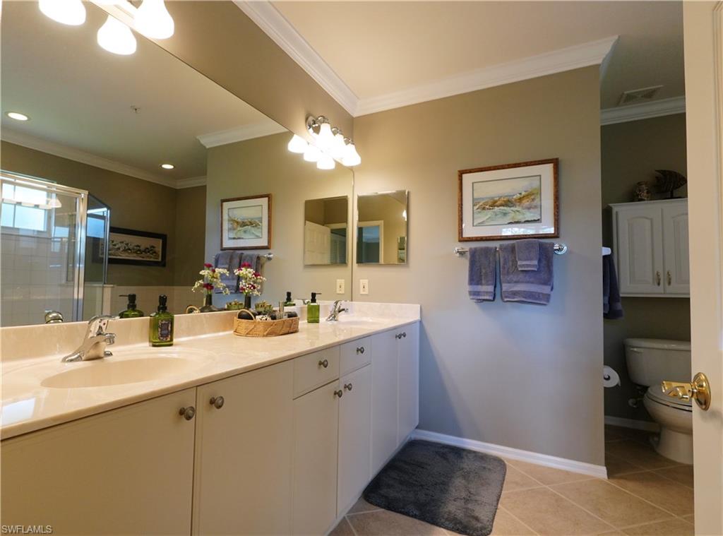 8165 Celeste Drive, Unit 2228 Naples, FL 34113 - Photo 18 of 30 a bathroom with a double vanity sink and a mirror