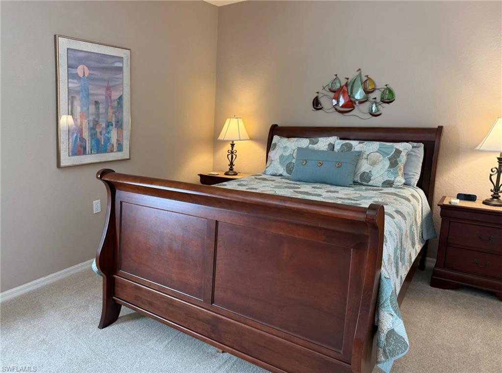 8165 Celeste Drive, Unit 2228 Naples, FL 34113 - Photo 20 of 30 a bedroom with a bed and a painting on the wall