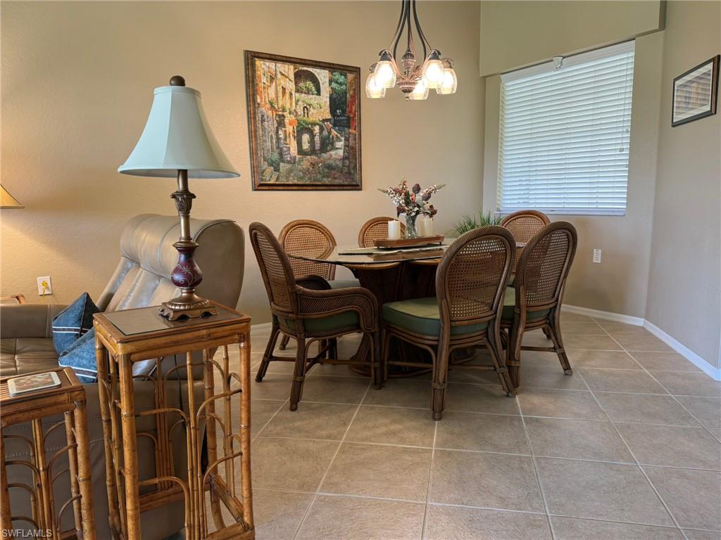 8165 Celeste Drive, Unit 2228 Naples, FL 34113 - Photo 9 of 30 a view of a dining room with furniture and chandelier